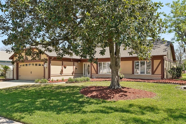 view of front facade with brick siding, an attached garage, a front yard, stucco siding, and driveway