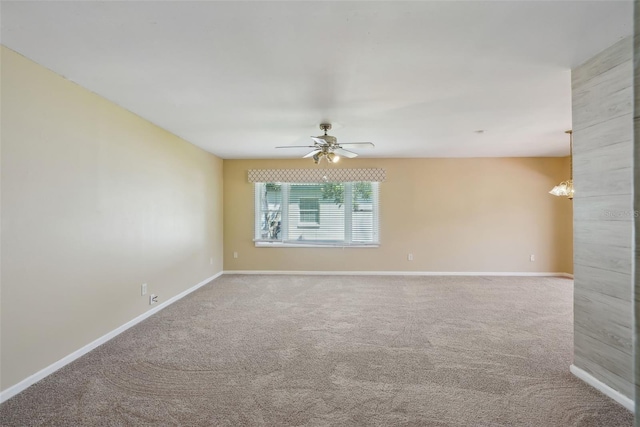 carpeted spare room with baseboards and ceiling fan