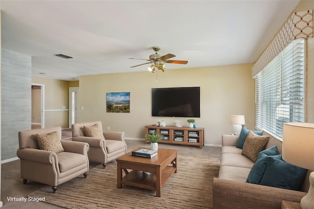 carpeted living room with a ceiling fan, visible vents, and baseboards