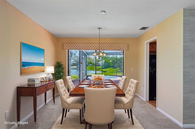 dining room featuring visible vents, light colored carpet, baseboards, and an inviting chandelier