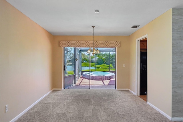 unfurnished room with visible vents, baseboards, a chandelier, and carpet flooring