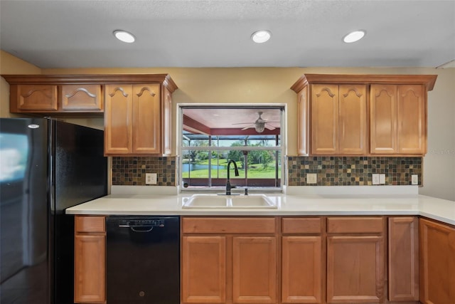 kitchen featuring backsplash, light countertops, recessed lighting, black appliances, and a sink