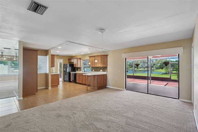 kitchen featuring visible vents, black appliances, open floor plan, light countertops, and light colored carpet