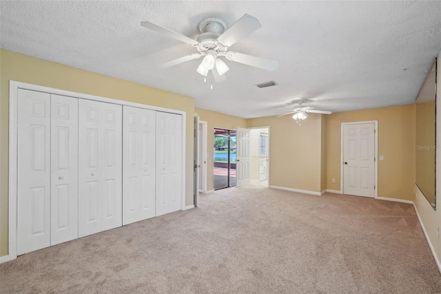 unfurnished bedroom with visible vents, ceiling fan, carpet floors, a textured ceiling, and access to outside