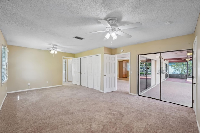 unfurnished bedroom featuring visible vents, baseboards, carpet floors, ceiling fan, and access to exterior