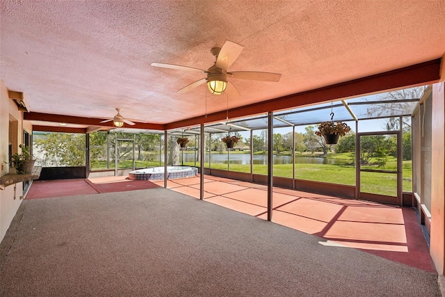 unfurnished sunroom featuring a water view, plenty of natural light, and ceiling fan