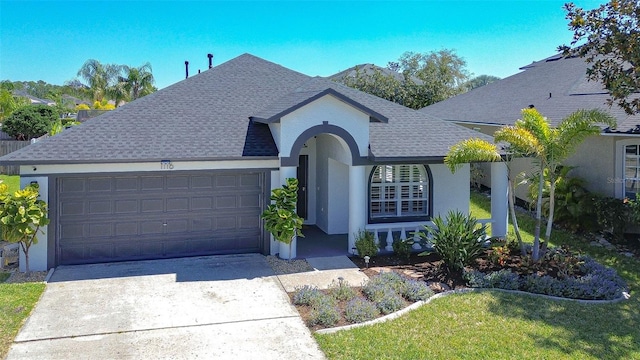 view of front of home featuring a garage, concrete driveway, stucco siding, and a shingled roof