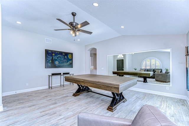 recreation room with light wood finished floors, visible vents, arched walkways, and vaulted ceiling