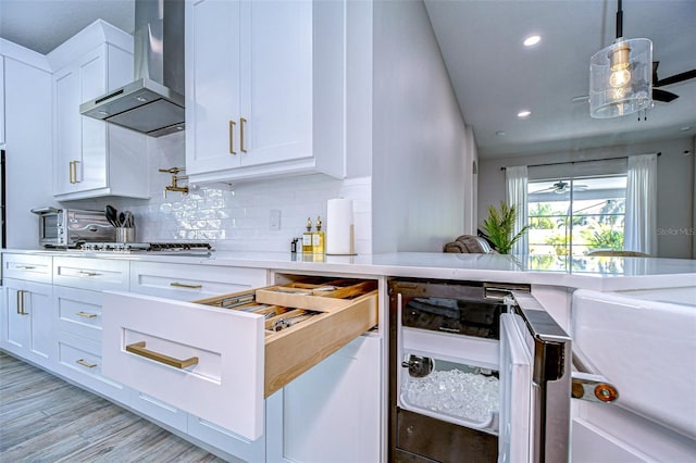 kitchen with beverage cooler, backsplash, white cabinetry, wall chimney exhaust hood, and light countertops