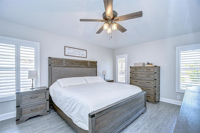 bedroom featuring baseboards, wood finish floors, and a ceiling fan