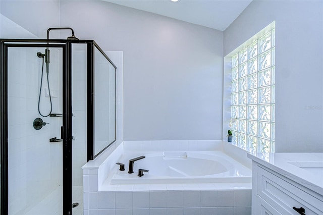 bathroom featuring vanity, a shower stall, and a garden tub