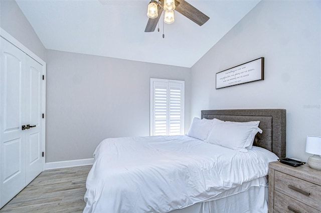 bedroom with baseboards, light wood-style floors, lofted ceiling, and a ceiling fan