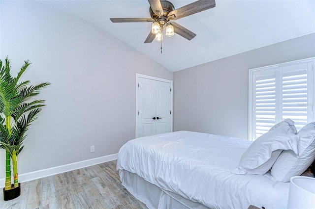 bedroom featuring baseboards, ceiling fan, vaulted ceiling, and light wood finished floors