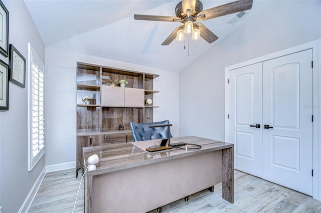 office area featuring light wood-type flooring, visible vents, ceiling fan, and vaulted ceiling