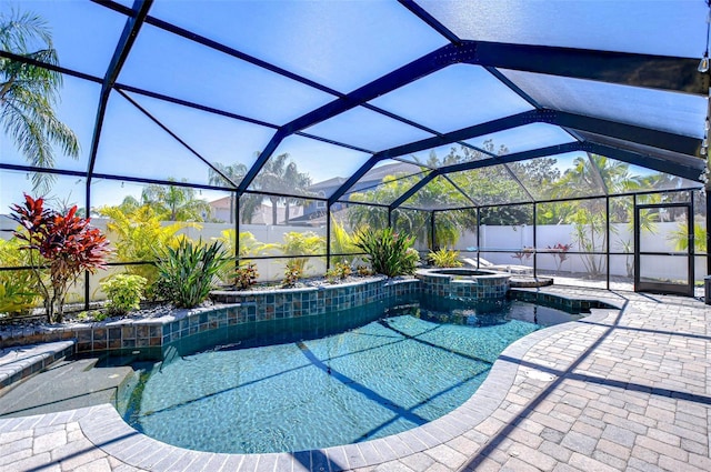 view of pool with a fenced backyard, glass enclosure, a pool with connected hot tub, and a patio