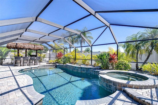 view of swimming pool with glass enclosure, a patio, a pool with connected hot tub, and outdoor dry bar