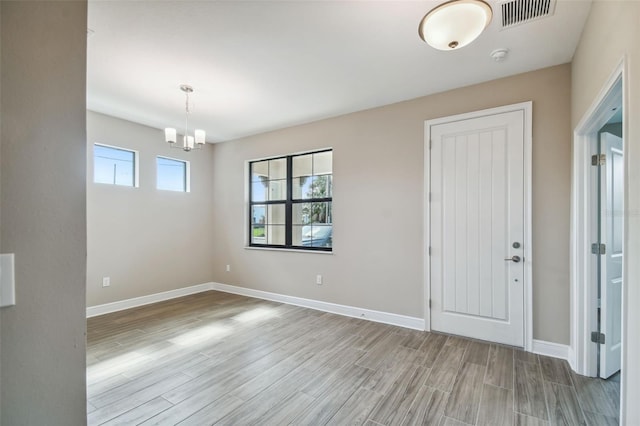 interior space with wood finished floors, visible vents, and baseboards