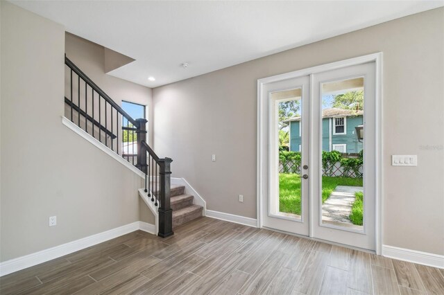 foyer entrance with stairs, recessed lighting, wood finished floors, and baseboards