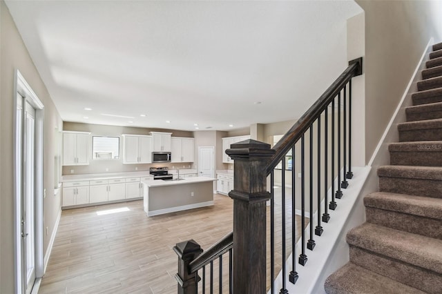 stairway with recessed lighting, baseboards, and wood finished floors