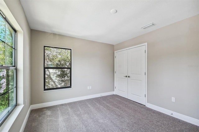 unfurnished bedroom featuring multiple windows, baseboards, and visible vents