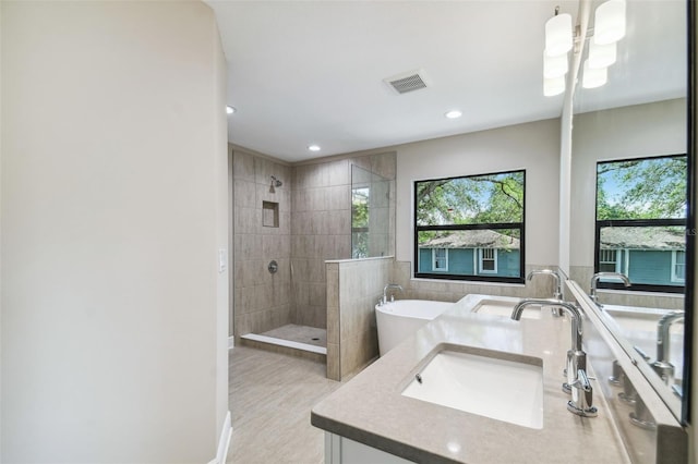 bathroom featuring visible vents, recessed lighting, tiled shower, a soaking tub, and vanity