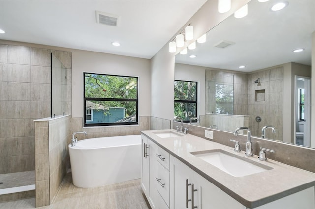 full bath with visible vents, a walk in shower, and a sink