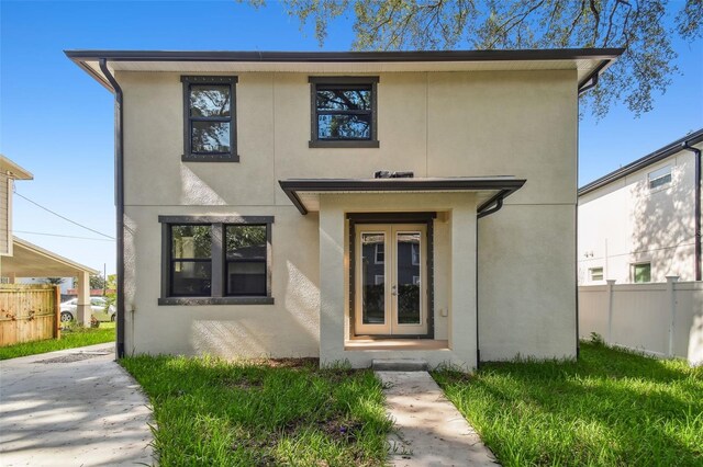 view of front of house featuring stucco siding, french doors, and fence