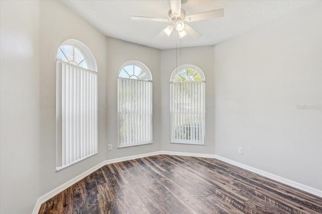 spare room featuring a ceiling fan, wood finished floors, baseboards, and a textured ceiling