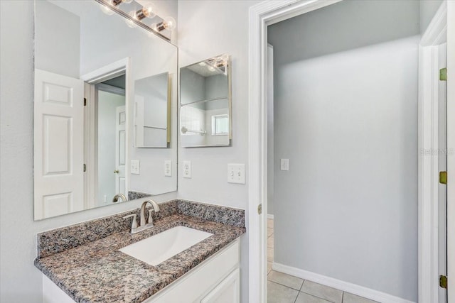 bathroom with tile patterned floors, vanity, and baseboards