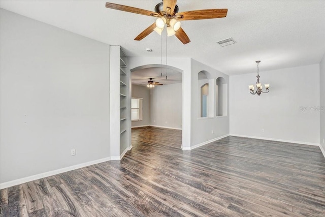 unfurnished room featuring visible vents, ceiling fan with notable chandelier, a textured ceiling, and wood finished floors