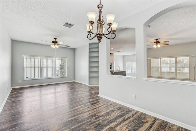 interior space featuring wood finished floors, ceiling fan with notable chandelier, visible vents, and a textured ceiling