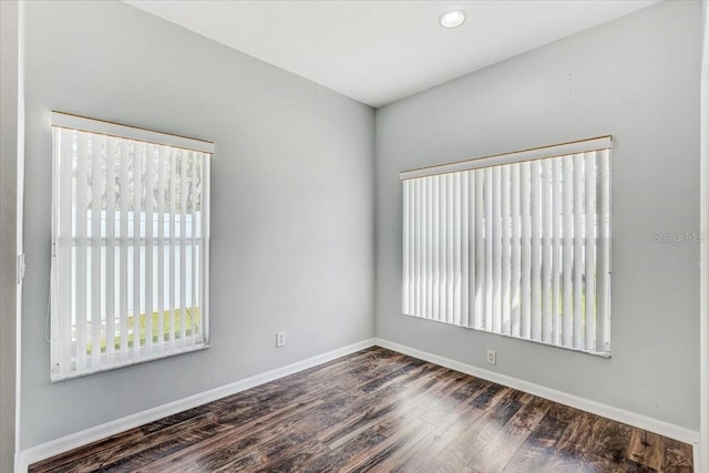 unfurnished room featuring baseboards and wood finished floors