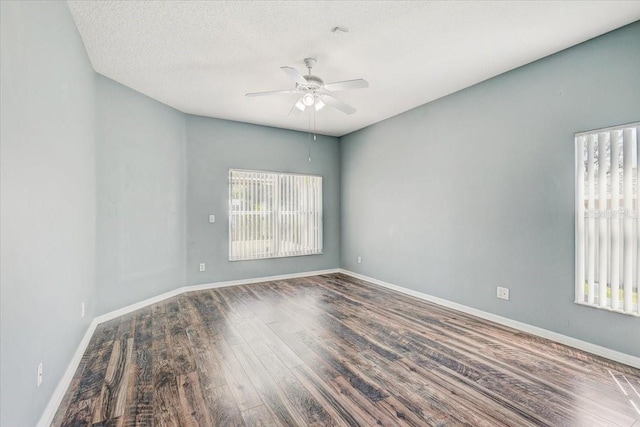 empty room featuring a textured ceiling, baseboards, ceiling fan, and wood finished floors