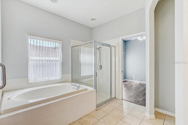 bathroom featuring tile patterned floors, a bath, and a shower stall