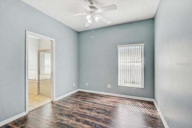 spare room with wood finished floors, baseboards, and ceiling fan