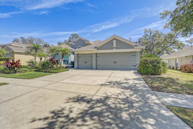 ranch-style home with stucco siding, driveway, and an attached garage