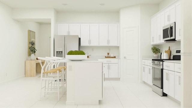 kitchen with a kitchen island, light countertops, appliances with stainless steel finishes, a kitchen breakfast bar, and white cabinets