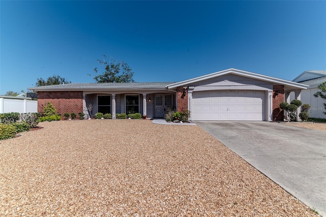 ranch-style house with brick siding, driveway, a garage, and fence