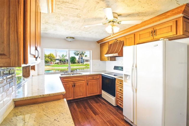 kitchen with white appliances, light stone countertops, a sink, dark wood-type flooring, and custom range hood