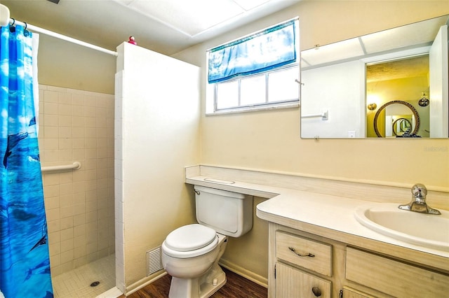 full bathroom with toilet, tiled shower, vanity, and wood finished floors