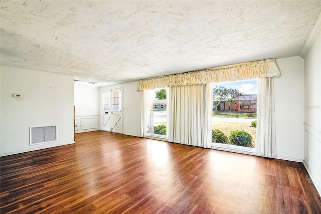 spare room featuring visible vents, a textured ceiling, and wood finished floors