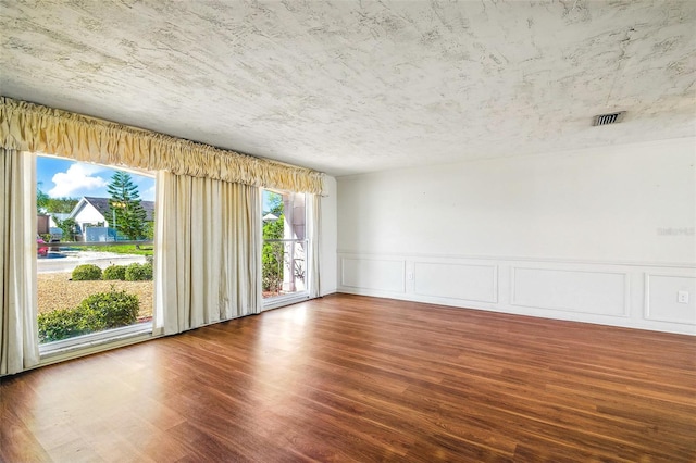 unfurnished room featuring visible vents and wood finished floors