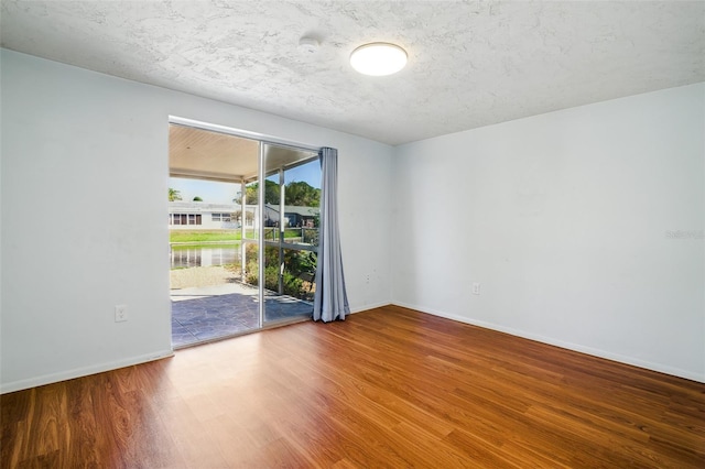 spare room featuring wood finished floors and baseboards