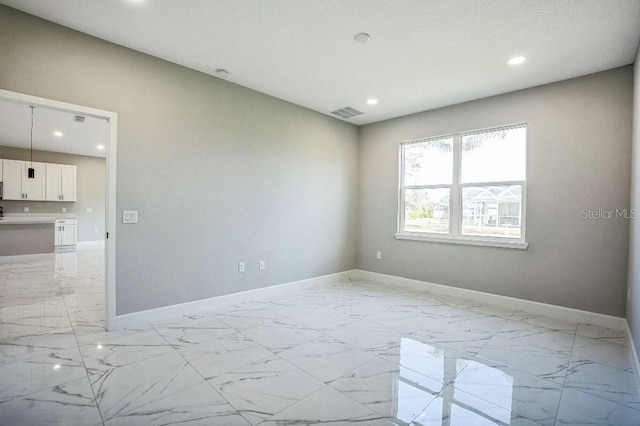 spare room featuring recessed lighting, visible vents, baseboards, and marble finish floor