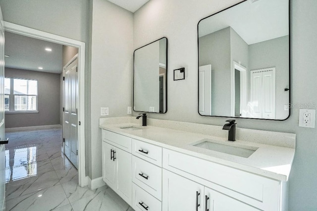 full bathroom with a sink, baseboards, and marble finish floor