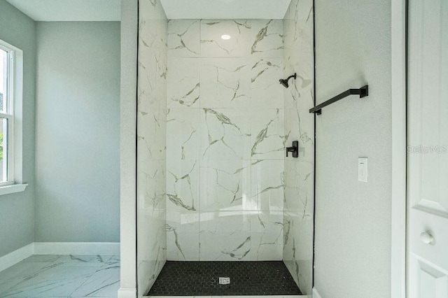 full bathroom with a marble finish shower, a healthy amount of sunlight, marble finish floor, and baseboards