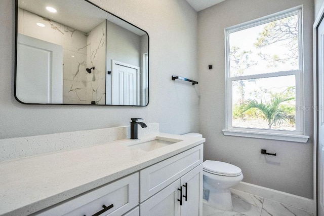 full bathroom featuring toilet, marble finish floor, a marble finish shower, baseboards, and vanity