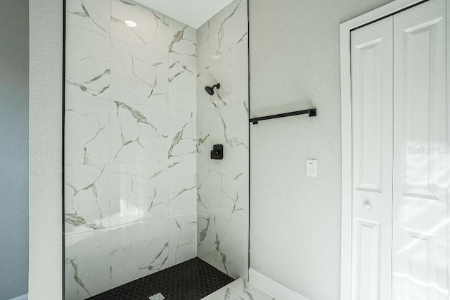 full bath with marble finish floor and a marble finish shower