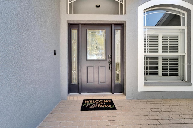 entrance to property with stucco siding