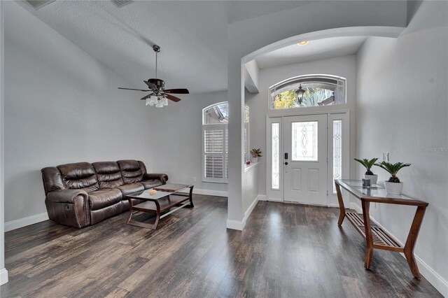 entrance foyer with wood finished floors, baseboards, and arched walkways